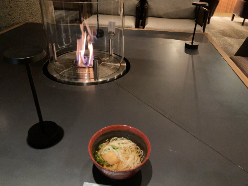 「秋保風雅」の夜食で提供された「白石温麺」を暖炉のテーブルに置いている様子